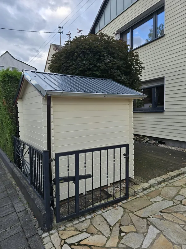 Gartenhaus mit heller Holzverkleidung und neuem dunklem Blechdach
